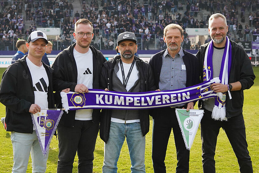 Verantwortliche vom SFV und FC Erzgebirge Aue mit einem Aue-Schal im Stadion.